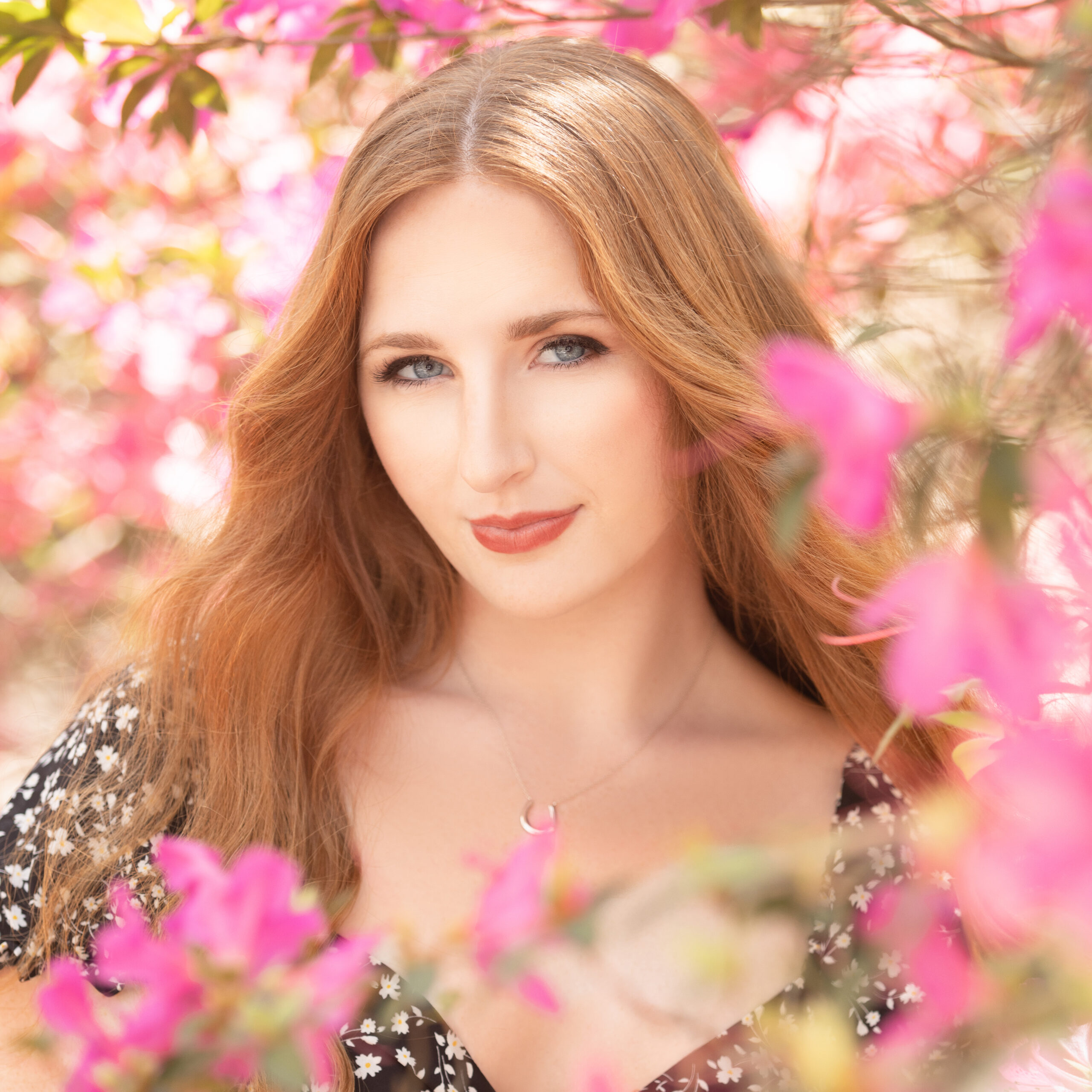 graduating senior surrounded by pink flowers at chesnut park