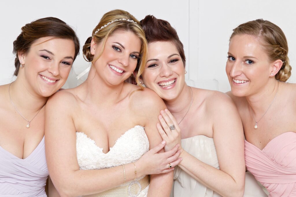 bride and bridesmaid smiling for the camera- how to look good in wedding photos