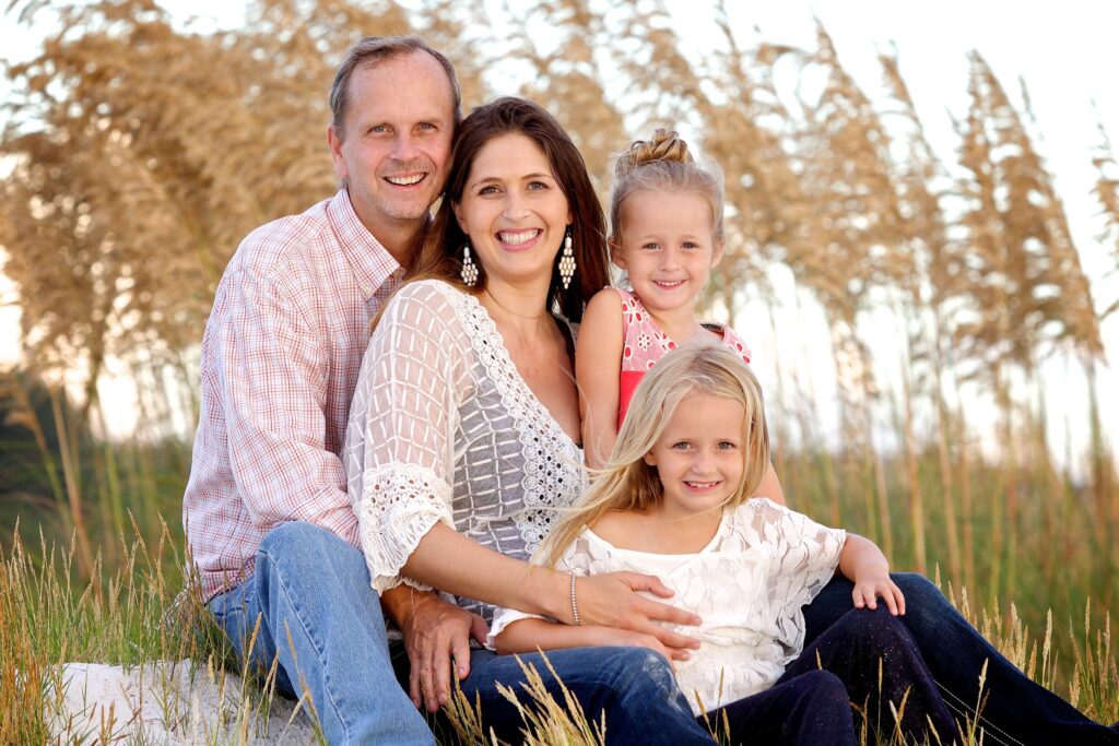 family photos - family of 3 in a field during golden hour