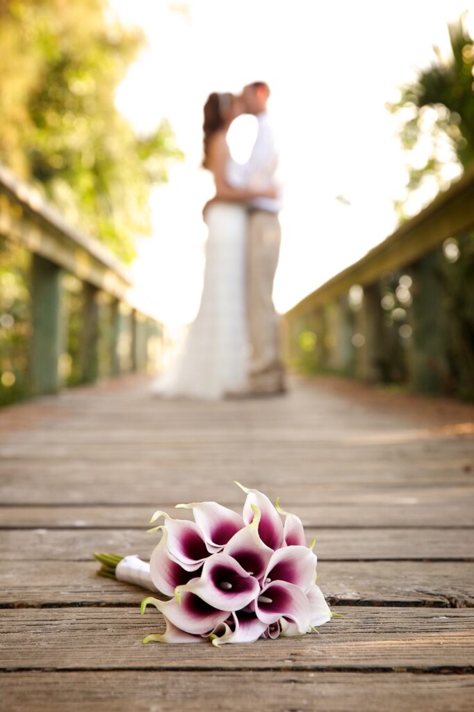 Couple on Wedding Day on beach near Tampa Bay - focus on flower bouquet 