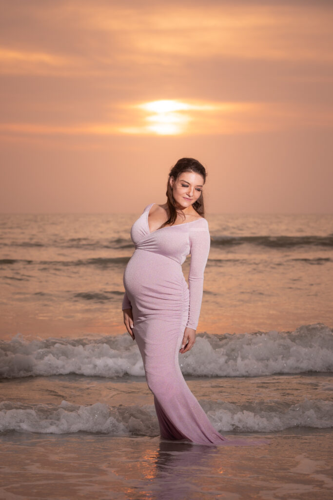 woman on the beach posting for her maternity photoshoot in Florida