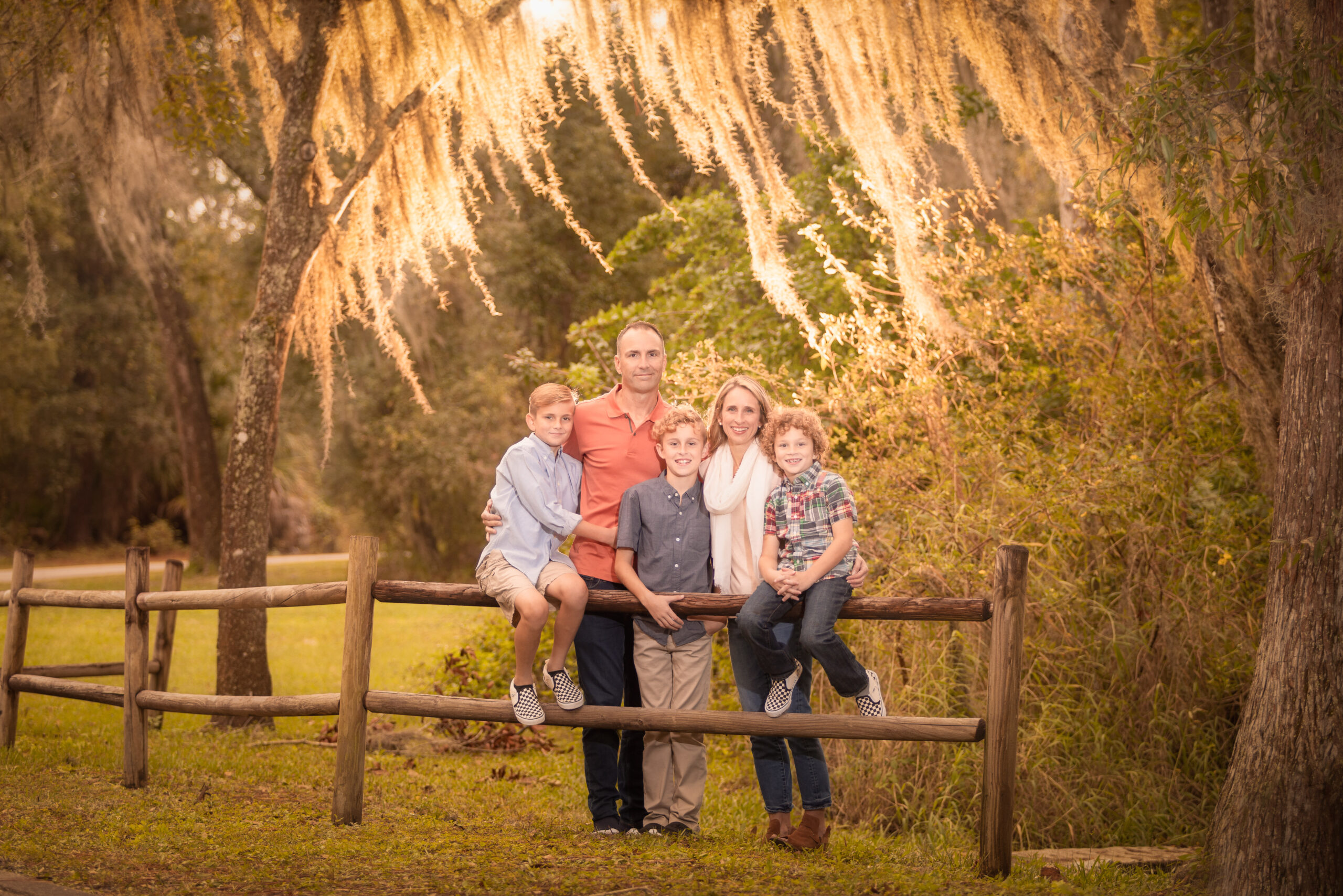 family of 5 hanging out in a park in Tampa under beautiful tress