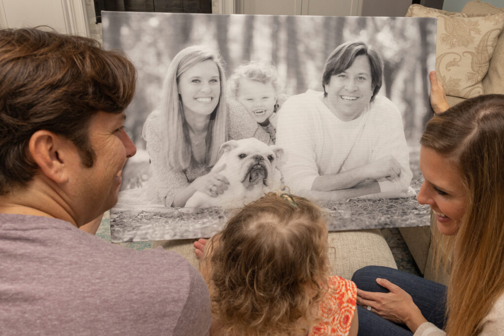 family looking at their professional photo prints on a canvas