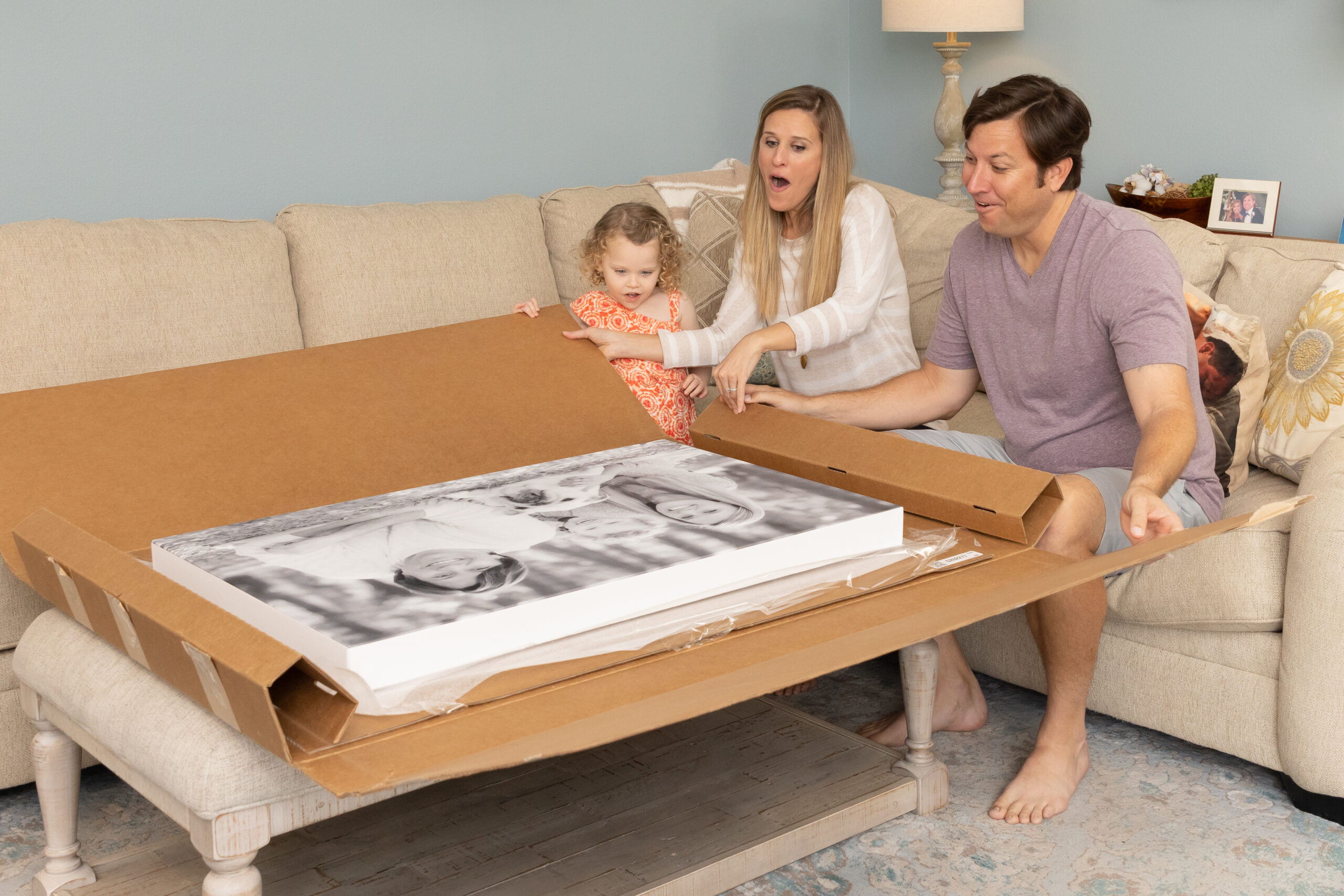 family of 3 opening their photo prints done professionally by their photographer