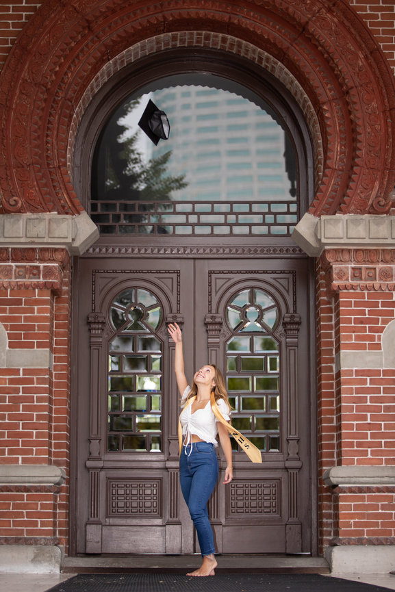 high school senior throwing cap in the air for her senior pictures in Tampa 