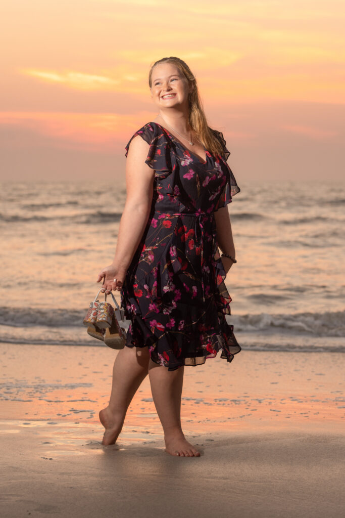 high school senior girl wearing a black floral dress on the beach - what to wear for senior pictures 