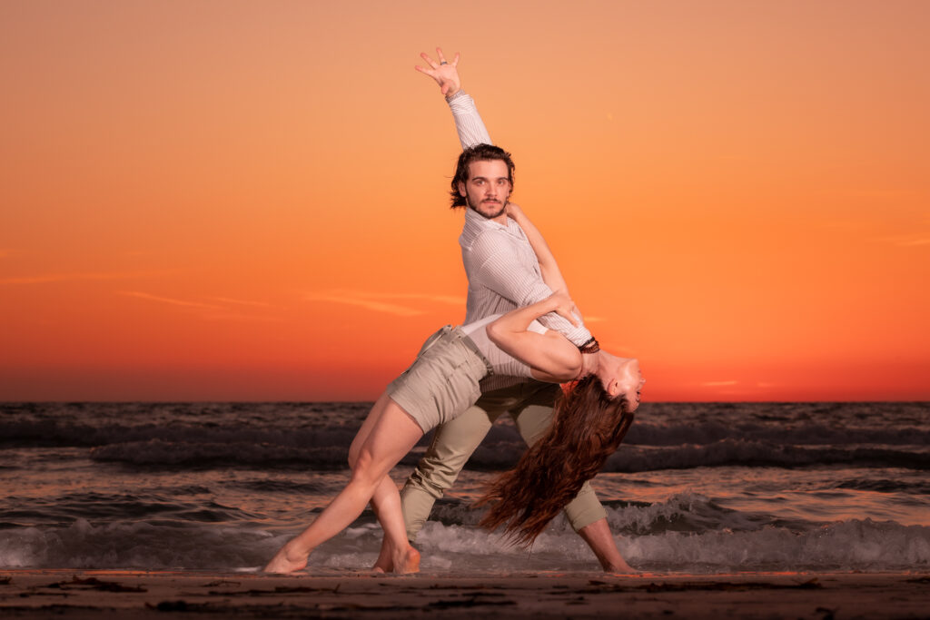 couple wearing khakis and white shirts for their engagement photoshoot at the beach