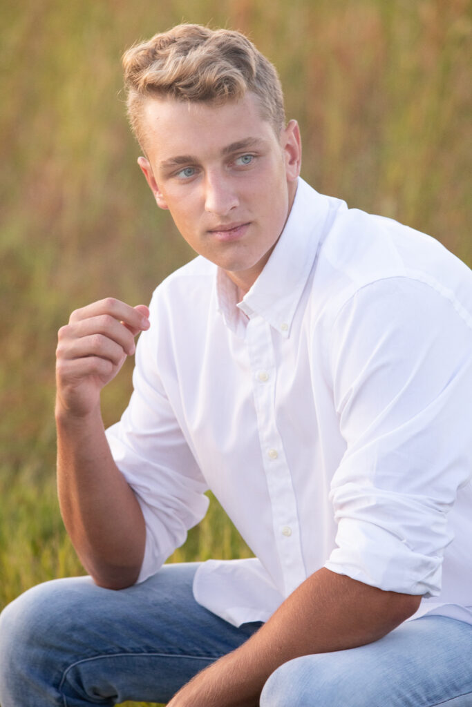 blonde senior guy wearing a white button down for photoshoot