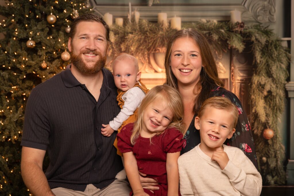 Family of 5 wearing perfect holiday wardrobe for Christmas studio backdrop in Tampa